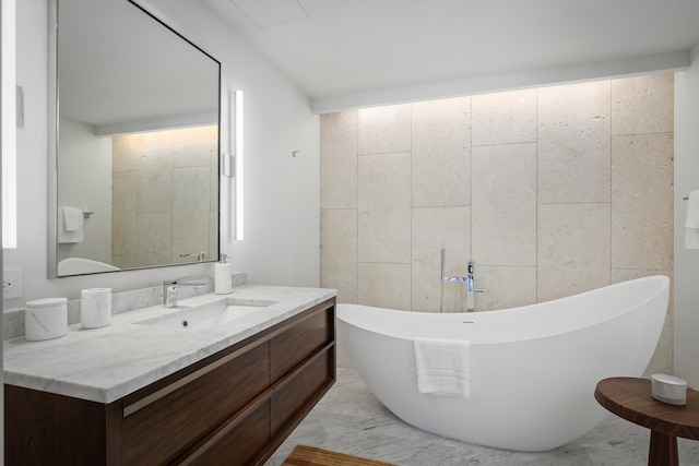 bathroom with vanity, tile walls, and a bathing tub