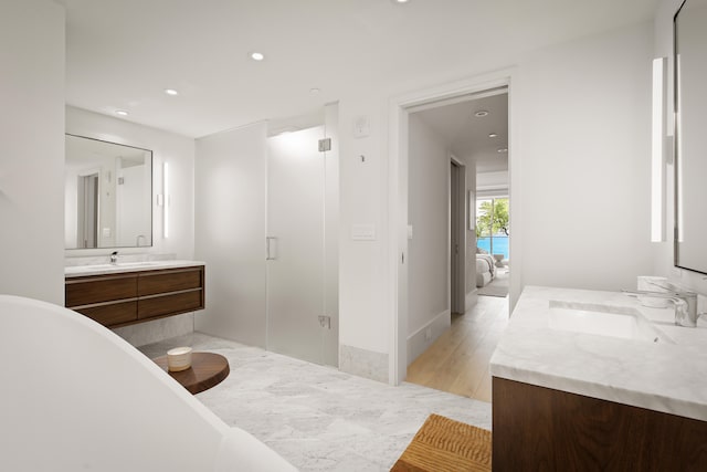 bathroom featuring hardwood / wood-style floors, shower with separate bathtub, and vanity