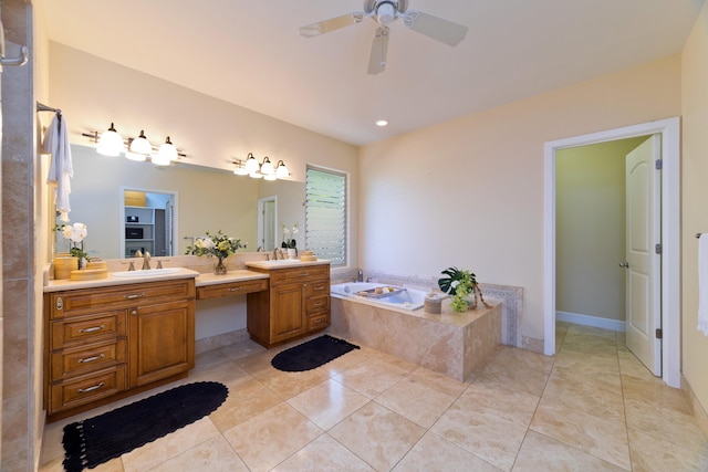 bathroom with tile patterned flooring, vanity, a relaxing tiled tub, and ceiling fan