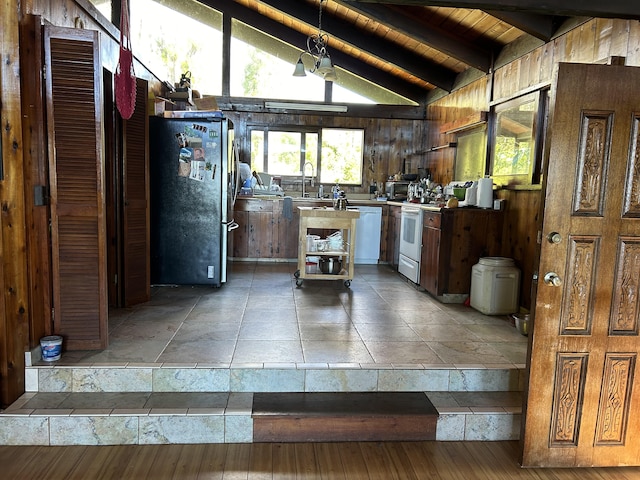 kitchen with sink, wood walls, wood ceiling, vaulted ceiling with beams, and white appliances