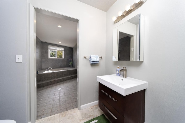 bathroom featuring tiled bath, tile patterned flooring, and vanity