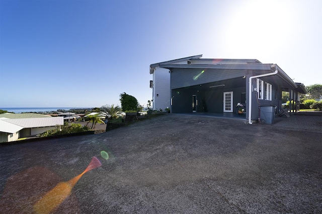 view of property exterior with a water view and a carport