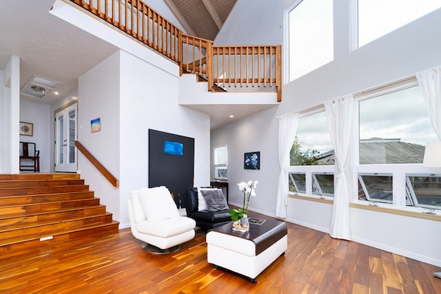 living room featuring wood-type flooring and a high ceiling