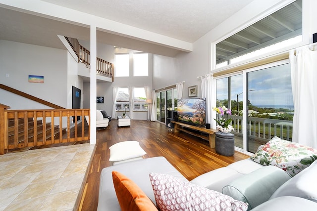 living room with a high ceiling, a textured ceiling, and hardwood / wood-style flooring