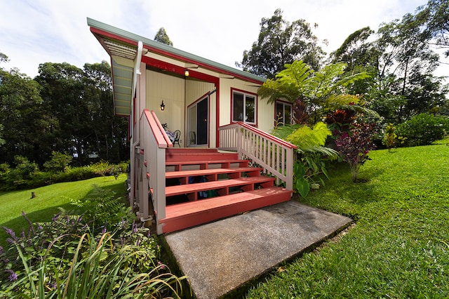 view of exterior entry with a yard