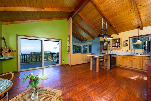 kitchen with stainless steel range, dark hardwood / wood-style flooring, hanging light fixtures, and beamed ceiling