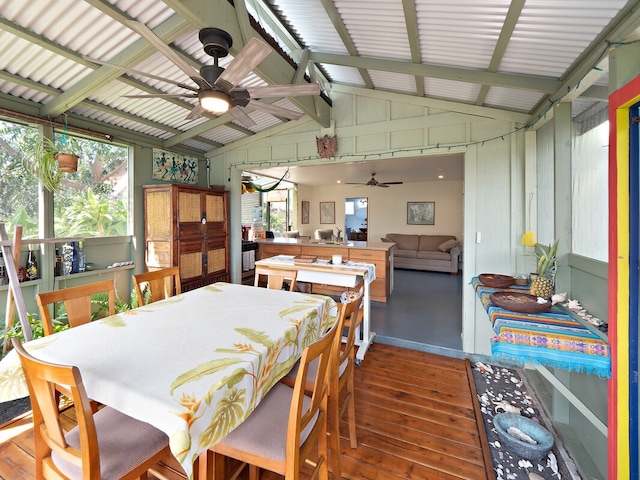 dining space featuring ceiling fan, dark hardwood / wood-style flooring, and vaulted ceiling with beams