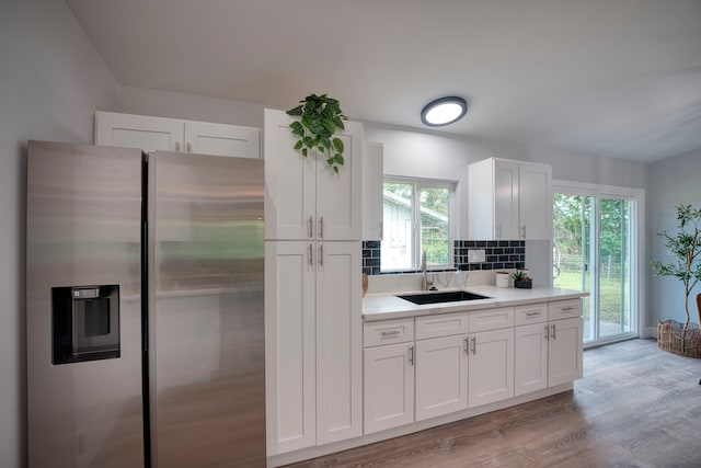 kitchen featuring white cabinets, plenty of natural light, and stainless steel refrigerator with ice dispenser