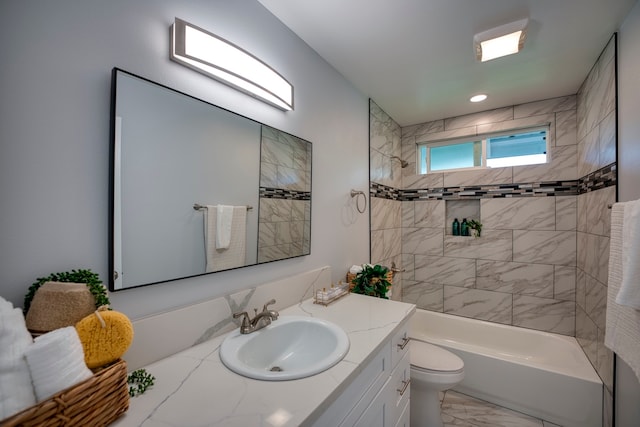 full bathroom with vanity, tiled shower / bath combo, and toilet