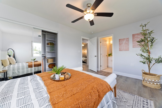 bedroom featuring hardwood / wood-style floors, a closet, ensuite bath, and ceiling fan