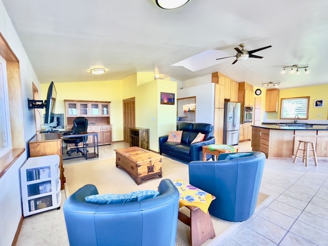 tiled living room with ceiling fan, sink, and lofted ceiling