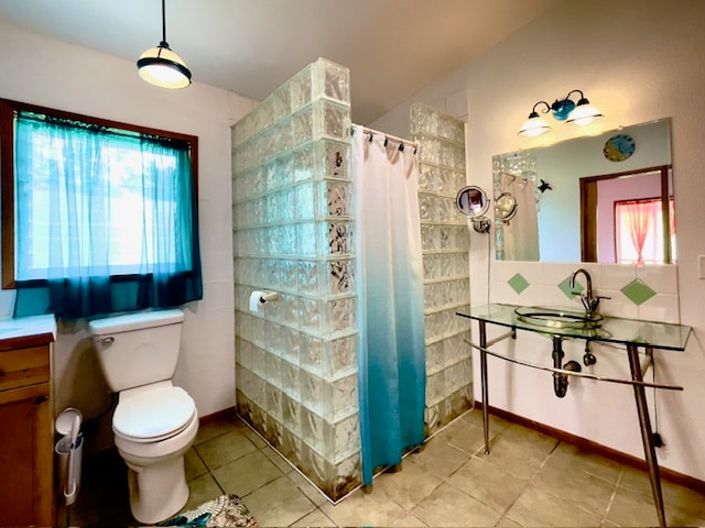 bathroom with tile patterned floors, vanity, and a healthy amount of sunlight