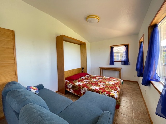 bedroom with tile patterned flooring and lofted ceiling