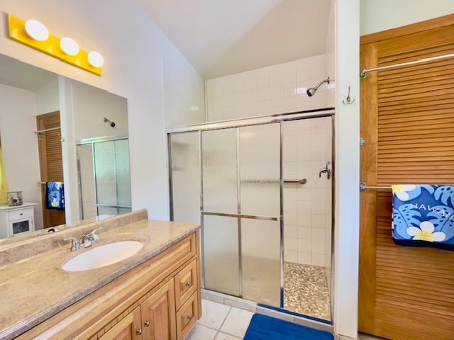 bathroom featuring tile patterned flooring, vanity, and a shower with shower door