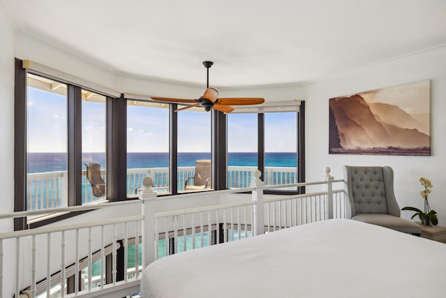 bedroom with crown molding, a water view, and ceiling fan