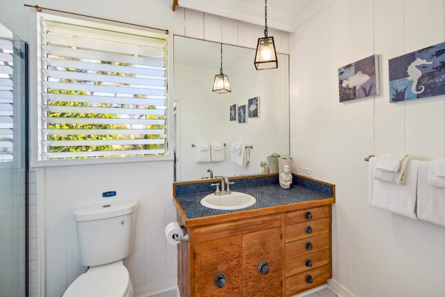 bathroom with vanity, toilet, ornamental molding, and a shower with shower door