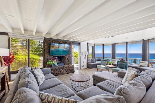 sunroom featuring beamed ceiling and a fireplace