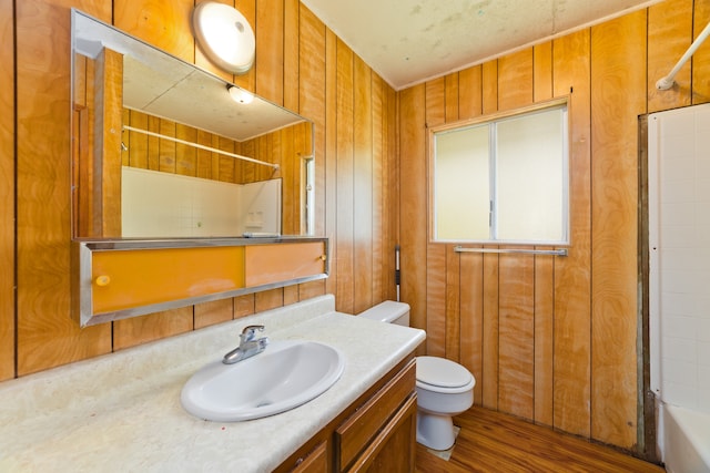 full bathroom with vanity, toilet, wood-type flooring, and wooden walls