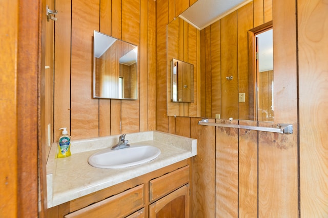 bathroom with vanity and wood walls