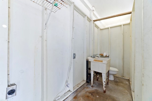 bathroom featuring toilet and concrete flooring