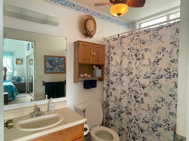 bathroom with vanity, curtained shower, toilet, and ceiling fan