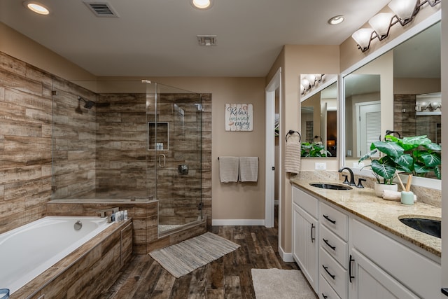 bathroom with hardwood / wood-style floors, vanity, and shower with separate bathtub