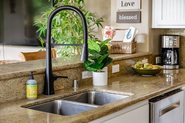 room details featuring sink and white cabinets