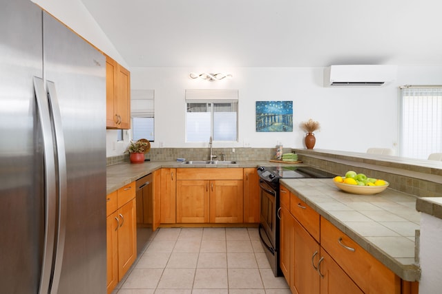 kitchen with sink, stainless steel appliances, a wall mounted AC, tile countertops, and light tile patterned flooring