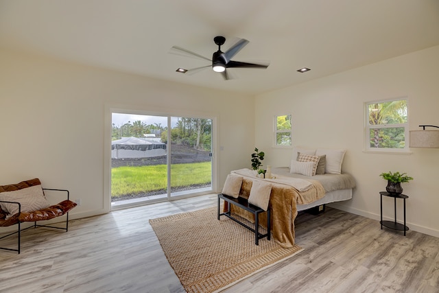 bedroom featuring ceiling fan, light hardwood / wood-style floors, access to outside, and multiple windows