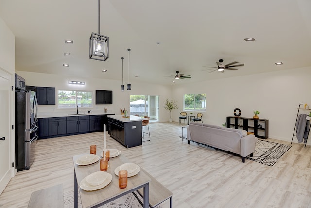 living room with light wood-type flooring, ceiling fan, and sink