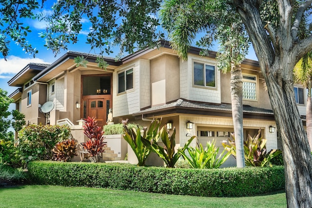 view of front of home featuring a front yard and a garage