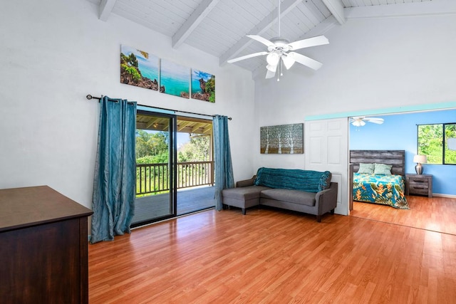 living room with beamed ceiling, ceiling fan, high vaulted ceiling, and light hardwood / wood-style flooring