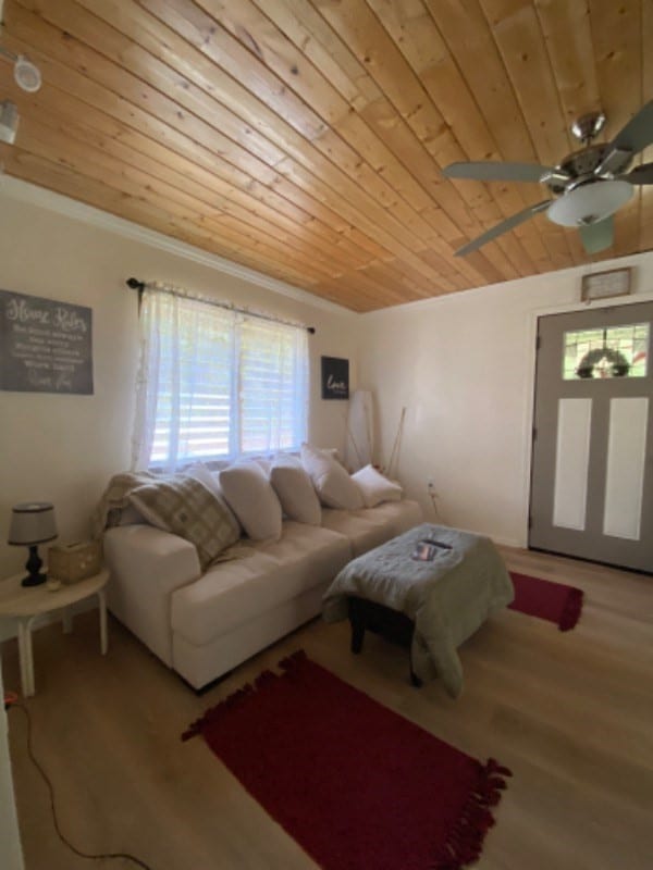 living room featuring ornamental molding, hardwood / wood-style flooring, wooden ceiling, and ceiling fan