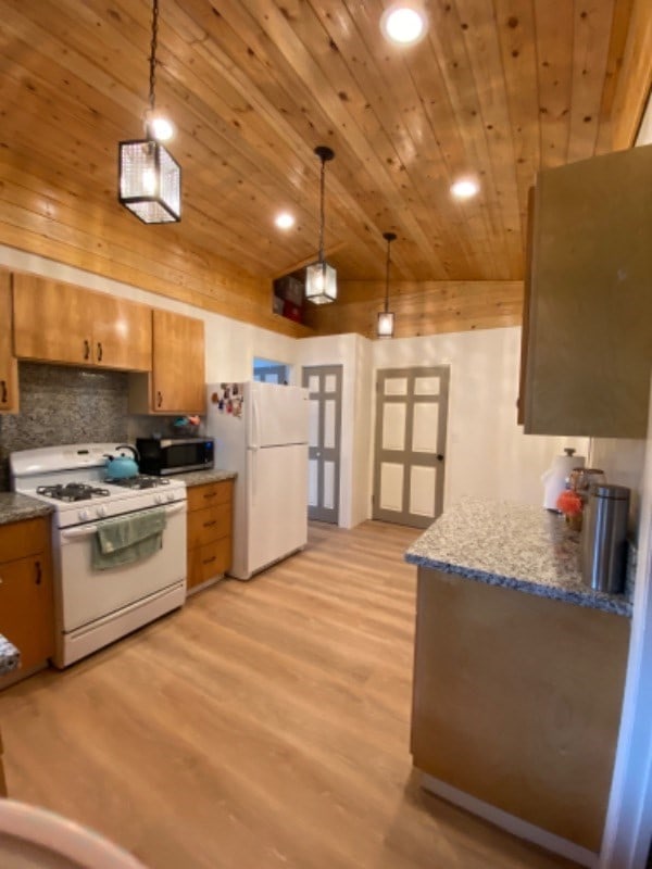 kitchen with lofted ceiling, hanging light fixtures, white appliances, and wood ceiling