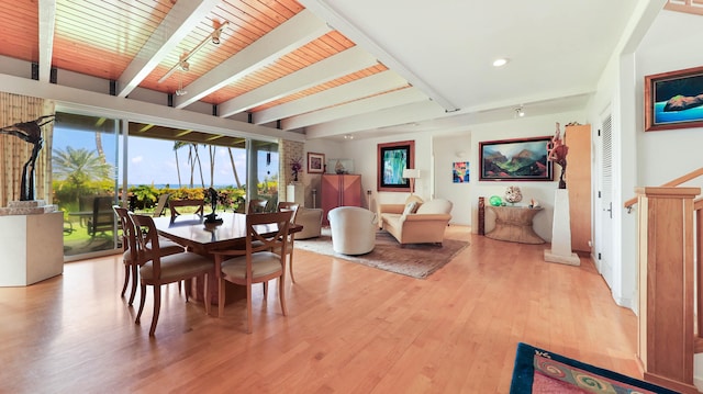 dining area featuring light hardwood / wood-style flooring, beamed ceiling, and wooden ceiling