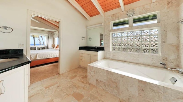 bathroom with tiled tub, wooden ceiling, vanity, and lofted ceiling with beams