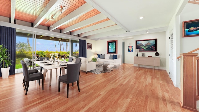 dining area featuring beam ceiling, light wood-type flooring, and wood ceiling