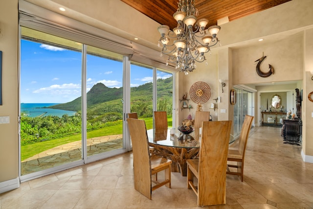 dining space featuring a water and mountain view, wooden ceiling, and an inviting chandelier