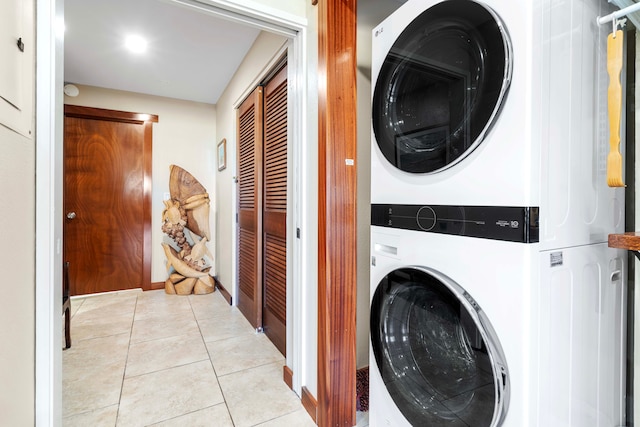 laundry area featuring stacked washer and dryer and light tile patterned floors