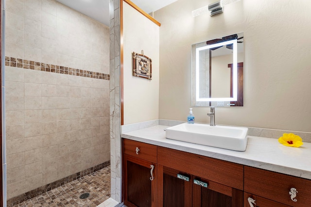 bathroom with vanity and tiled shower