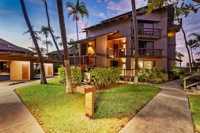 exterior space with a lawn and a balcony