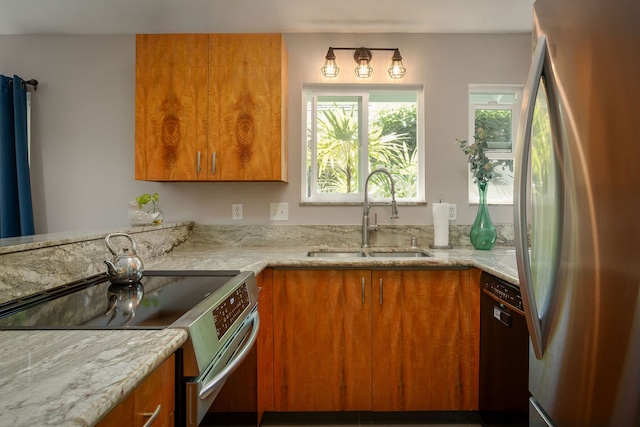 kitchen featuring light stone countertops, appliances with stainless steel finishes, and sink