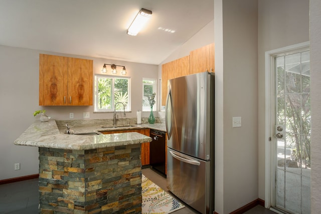 kitchen featuring sink, black dishwasher, kitchen peninsula, stainless steel fridge, and lofted ceiling