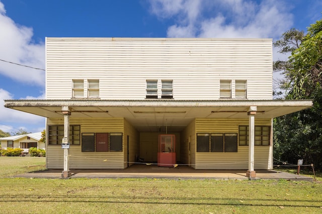 rear view of house featuring a lawn