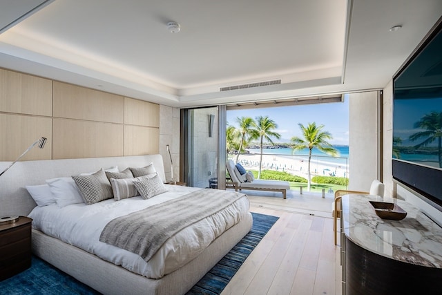 bedroom featuring hardwood / wood-style floors and a tray ceiling