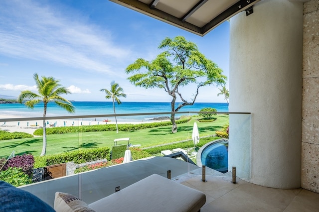 balcony featuring a view of the beach, a water view, and a patio area