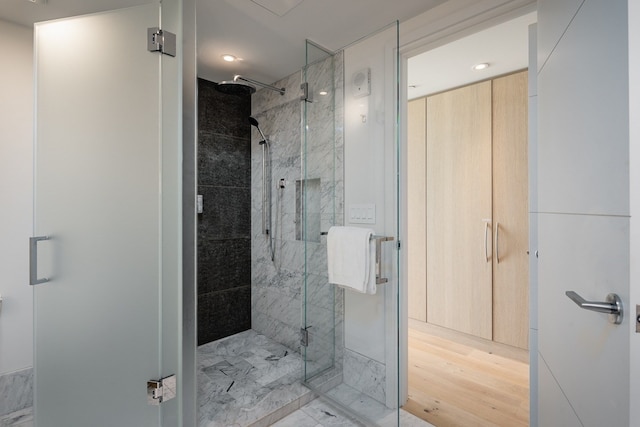 bathroom with an enclosed shower and hardwood / wood-style flooring