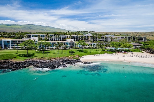 drone / aerial view with a water and mountain view and a beach view