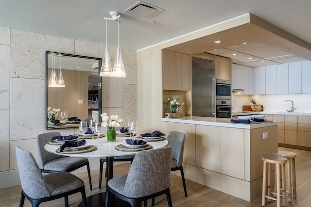 dining area featuring light hardwood / wood-style floors and sink