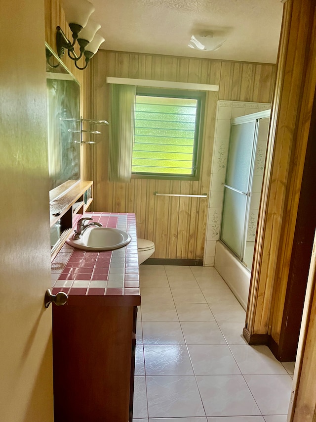 full bathroom with toilet, wood walls, and vanity